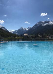 duży basen z niebieską wodą z górami w tle w obiekcie Studio in Klosters w mieście Klosters