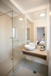 La salle de bains est pourvue d'un lavabo et d'une douche en verre. dans l'établissement Pensiunea Sada, à Cluj-Napoca