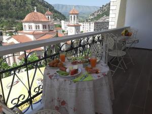 een tafel met een bord eten op een balkon bij HOTEL VILA TWIX in Berat