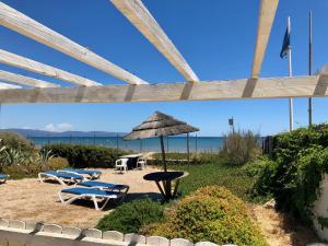 a patio with a table and chairs and an umbrella at Ô Bord de Mer ! in Hyères