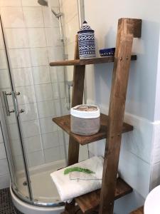 a wooden shelf in a bathroom with a shower at AUX ROSIERS in Salies-de-Béarn