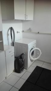 a kitchen with a washing machine and a black bag at Ferienwohnung nahe Ulm/Laupheim in Laupheim