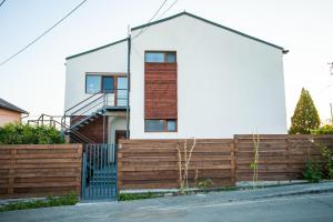 a house with a wooden fence in front of it at Pensiunea Sada in Cluj-Napoca