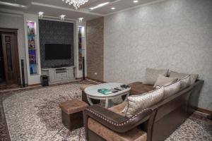 a living room with a couch and a tv at Favorite apartment in Samarkand