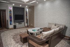 Una sala de estar con un sofá y un televisor. en Favorite apartment, en Samarkand