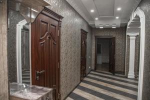 Un pasillo con una puerta de madera en un edificio. en Favorite apartment, en Samarkand 14 fotos más