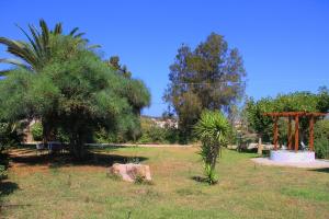 un parque con un árbol y una roca en el césped en Ilias Apartments, en Methoni