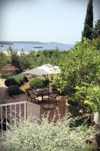 a patio with a table and an umbrella at Apartments Giardino in Hvar