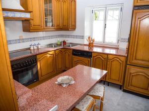 PortelaにあるCasa rural quirogaの木製のキャビネットとカウンタートップを備えたキッチン