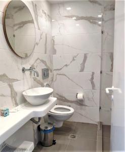 阿達瑪斯的住宿－Corali Hotel，一间带卫生间、水槽和镜子的浴室