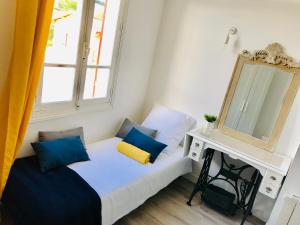 una piccola camera da letto con un letto e uno specchio di Le Clos de la Gravette a Bessières