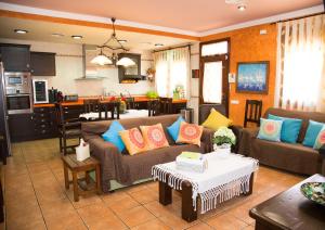 een woonkamer met 2 banken en een keuken bij Villa Ca La Vicen in Deltebre