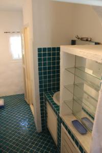 La salle de bains est pourvue de carrelage vert et d'un lavabo. dans l'établissement Les Amandiers - 5 km de la plage, à Sainte-Maxime