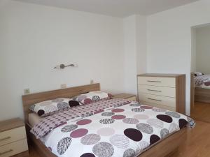 a bedroom with a bed with a polka dot blanket at Apartman Ivana in Porat