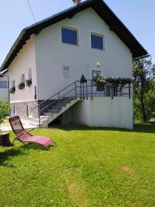 une maison avec une chaise en face dans l'établissement Guest House First Stop, à Rakovica