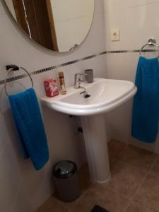 a bathroom with a sink and a mirror and blue towels at La Sirena Baria15 in Villaricos +16 photos