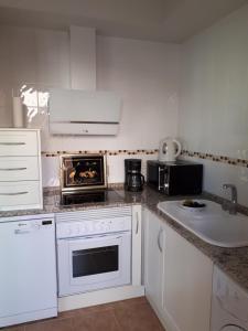 a kitchen with a stove top oven next to a sink at La Sirena Baria15 in Villaricos