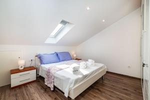 um quarto com uma cama com almofadas azuis em Apartman Dunatov em Preko