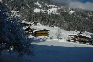 a ski lodge in the snow with a mountain at Pension Rosenegg in Finkenberg