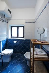une salle de bain bleue et blanche avec des toilettes et un lavabo dans l'établissement Casa Annuccia ai Quattro Canti di Città, à Palerme