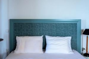 a bed with a green headboard and white pillows at Finisia House in Elia Laconias