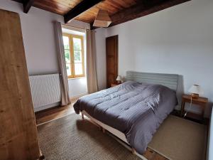 a bedroom with a bed and a large window at La Vallée in Saint-Pierre-Langers +28 photos