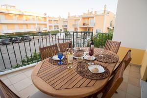 a wooden table with food and wine on a balcony at Villa Ria Rose, Alto da Ria 23 - jacuzzi and beach in Alvor