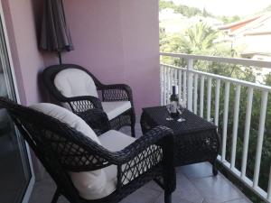 two chairs and a table on a balcony at Apartments Pecotić in Brna
