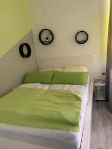 1 Schlafzimmer mit einem Bett mit grüner Bettwäsche und 2 Spiegeln in der Unterkunft Hahnenklee Ferienpark 6-244 in Goslar