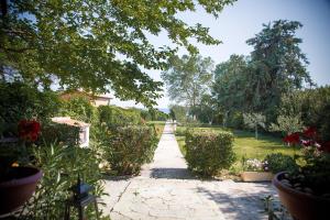 a path through a garden with flowers and trees at Estate Irene in Alexandroupoli