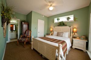 una camera con letto bianco e pareti verdi di DeSoto Beach Bed and Breakfast a Tybee Island