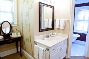 W łazience znajduje się umywalka i lustro. w obiekcie DeSoto Beach Bed and Breakfast w mieście Tybee Island