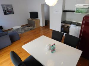 a white dining room table with chairs and a kitchen at Apartment Novigrad Holiday in Novigrad Dalmatia
