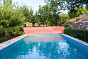 a swimming pool with blue water in a yard at El Zarzal in Horche