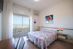 a bedroom with a bed and a view of the ocean at Hotel Continental in Caorle