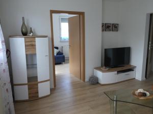 a living room with a flat screen tv and a table at Ferienwohnung Mainz-Weisenau in Mainz