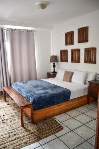 um quarto com uma cama com um cobertor azul em Cinco Hotel B&B em San Salvador