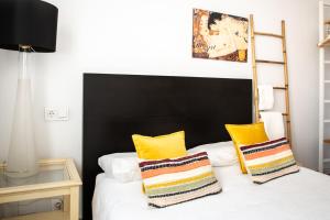 ビルバオにあるAresti Old Town by Bilbao Livingのベッドルーム1室(黒いヘッドボード、黄色い枕のベッド1台付)