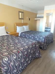 a hotel room with two beds in a room at Hotel Boulevard Mexicali in Mexicali