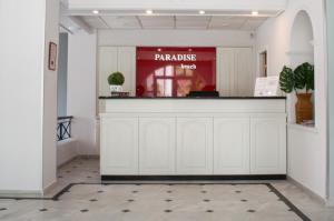 a bar in a lobby with avertisement for at Paradise Beach Hotel in Argassi