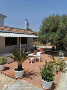 a patio with a table and chairs and plants at Casavacanze PugliaMia in Grottaglie