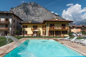 a house with a swimming pool in front of a mountain at Agritur Ai Masi in Pergolese