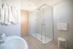 a bathroom with a glass shower and a sink at Hotel Continental in Caorle