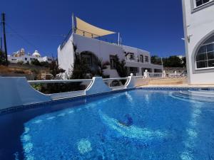 a white swimming pool with a blue sky at Sea of Aegeon in Fira