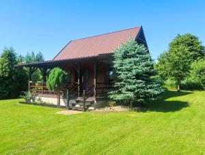 a log cabin with a tree in front of it at domek letniskowy in Urowo