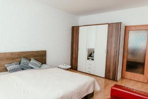 a bedroom with a white bed and a cabinet at Old Town Apartment Pellicova in Brno