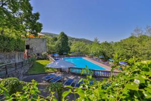 una piscina all'aperto con sedie e ombrelloni di Residence Il Castagno a Pistoia