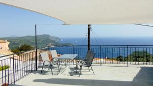 uma mesa e cadeiras numa varanda com vista para o oceano em Lakones View House em Lákones