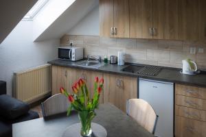 a kitchen with a table with a vase of flowers at Penzion Šárka in Karlovy Vary