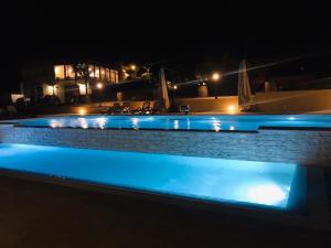 uma piscina à noite com luzes azuis em Agriturismo La Casa di Bacco em Agrigento